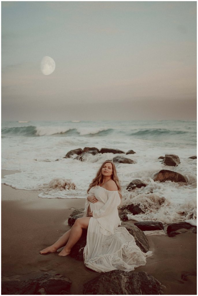 Pregnant women sitting on a rock by the beach in Boynton beach, Florida.